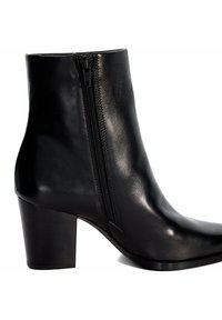 Bottine en cuir noir avec une texture lisse, dotée d'une fermeture éclair sur le côté, d'un bout rond et d'un talon épais.