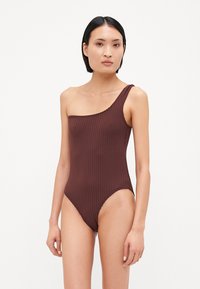 Traje de baño de una sola pieza en color marrón con un diseño de un hombro, tirante delgado y aberturas de pierna de corte alto, fabricado con una suave tela texturizada.