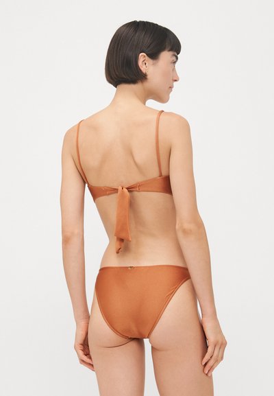 Zestaw bikini w rdzawym pomarańczowym kolorze, z regulowanymi cienkimi ramiączkami, wiązaniem z tyłu oraz gładkim, błyszczącym materiałem o minimalistycznym wzorze.