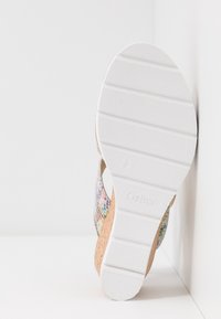 Sandale en liège avec une semelle en caoutchouc blanche, tige en maille multicolore, design ouvert et semelle intérieure texturée. Présente le logo de la marque sur la semelle.