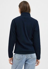 Pullover in pile color blu navy con colletto alto, maniche lunghe e texture morbida. Presenta una finitura pulita all'orlo e viene mostrata la vista posteriore.