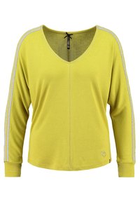 Long-sleeve yellow top made of a textured fabric, featuring a V-neck, silver side stripes, and a small heart detail at the hem.