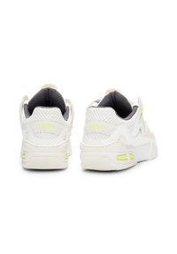 Sneakers bianchi con pannelli in rete, rivestimento interno grigio e sottili accenti verde neon. Presentano una suola chunky e un tallone testurizzato.