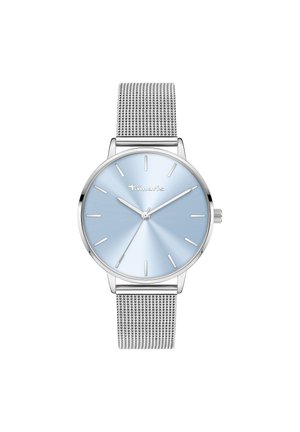 Montre en argent avec un cadran bleu clair, bracelet en métal maillé, design minimaliste, boîtier fin et marqueurs d'heure simples. Nom de la marque visible sur le cadran.