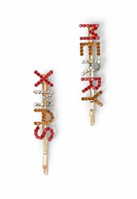 Zlaté vlásenky zdobené barevnými rhinestones v červené, oranžové a průhledné barvě. Každá vlásenka zobrazuje stylizovaná písmena vytvořená kamínky.