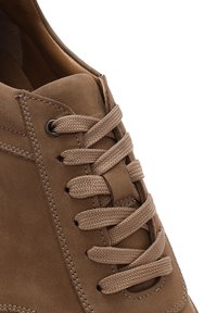 Scarpa in suede marrone con superficie testurizzata, punta rotonda e lacci piatti passati attraverso occhielli in metallo, con fodera interna liscia.