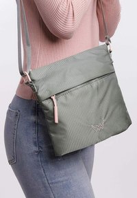 Šedá crossbody taška s texturovaným povrchem, zipovým uzávěrem a světle růžovými akcenty. Obsahuje nastavitelné ramenní popruhy a detaily s logem.