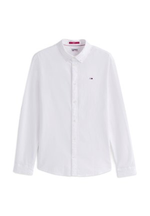 Camisa blanca de manga larga con botones, cuello y pequeño logo de Tommy Jeans en el lado izquierdo del pecho.