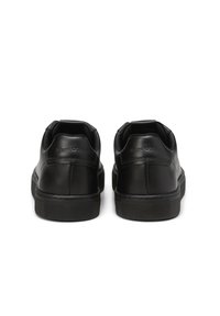 Schwarze Leder-Sneaker mit glatter Oberfläche, niedrigem Design und strukturiertem Gummisohle. Mit einem markierten Ferseneinsatz für zusätzlichen Detail.