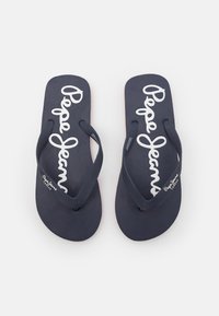 Marinblå flip-flops med texturerade sulor och gummiband. Har en vit "Pepe Jeans"-logotyp som är tydligt tryckt på fotbädden.