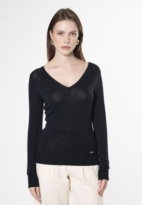 Langarmiger schwarzer Strickpullover mit V-Ausschnitt, leichtem Material, das einen dezenten Glanz aufweist, und einem kleinen Markenakzent am Saum.