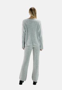 Grauer, gerippter Pullover und passende Hose aus weichem Material, entspannte Passform, mit langen Ärmeln und weitem Bein, von hinten gezeigt.