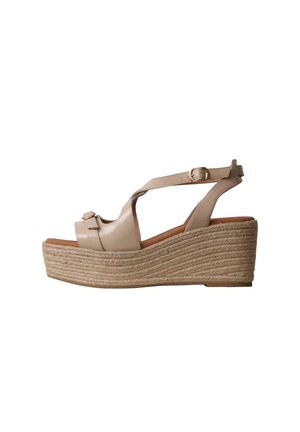 Sandale compensée en cuir beige avec bride cheville et boucle, dotée d’une épaisse semelle plateforme en jute tressé.