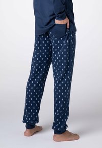 Pantaloni del pigiama navy con motivo a pois blu chiaro. Realizzati in materiale morbido, presentano polsini elasticizzati e tasche laterali per il comfort.