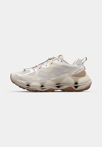 Lightweight white sneakers feature a mesh upper, textured accents, a thick, sculpted sole, and a rubber outsole with a brown tread pattern.