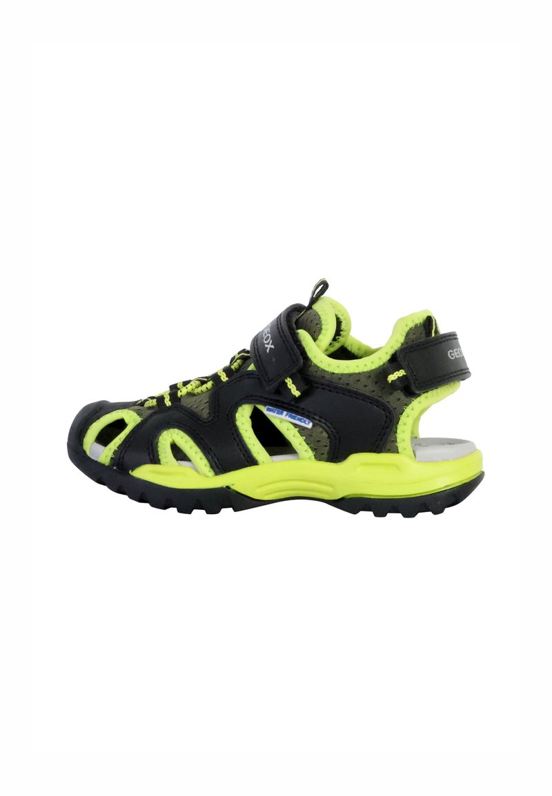 Sandalias infantiles negras y de color verde neón con malla transpirable, correa ajustable y suela resistente; cuentan con recortes para ventilación.