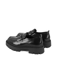 Zwarte leren loafers met een ronde neus, voorzien van een dikke rubberen zool en een opvallend profiel. Inclusief een decoratieve banddetail.