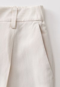 Beige linnen broeken met een textuurafwerking, voorzien van een rechte voorkant, zijzakken en een gestikte tailleband voor extra detail.