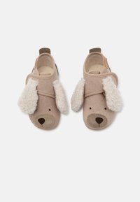 Tan-fargede sko designet som en hund med fluffy kremhvite ører, brun snute og broderte detaljer. Har en borrelåsrem for enkel påkledning.