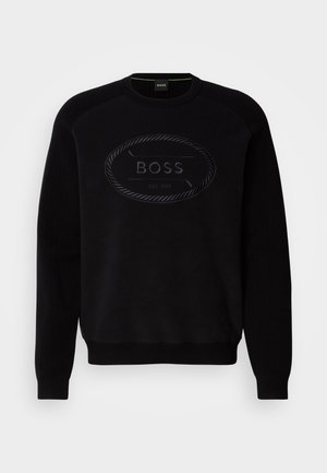 Sudadera negra con un cuello redondo acanalado y mangas raglán largas, con un detalle de logo texturizado en la parte frontal.