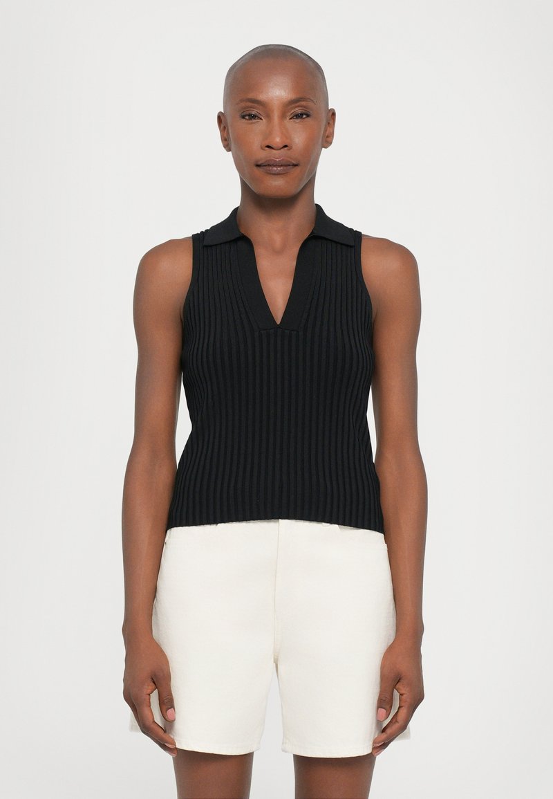 Black ribbed sleeveless top with a V-neck and collared design, paired with off-white, knee-length shorts, showcasing a smooth texture.