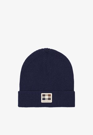 Cappellino blu lavorato a maglia con trama a coste e risvolto. Presenta un'etichetta rettangolare con un motivo a quadretti beige e marrone.