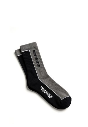Pair of black and gray socks with white text "FROM BERLIN WITH LOVE" on one sock and partially visible vertical text on the other.