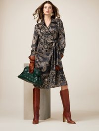 Rochie învăluită cu imprimeu paisley negru și auriu, cu mâneci lungi; mănuși din piele maronie; cizme maro până la genunchi; poșetă verde împletită; textură netedă.