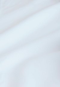 Biała tkanina o subtelnym prążkowanym wzorze, pokazana w delikatnych fałdach, przedstawiająca gładki i lekki materiał.