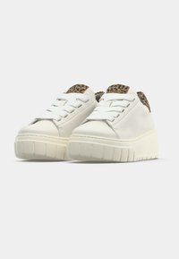 Baskets compensées blanches avec semelles épaisses, lacets blancs et détails imprimé léopard sur la languette et le col du talon.