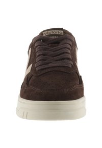 Sneaker in suede marrone con accenti beige, punta rotonda, suola piatta e lacci texturizzati. Presenta dettagli perforati sulla tomaia.
