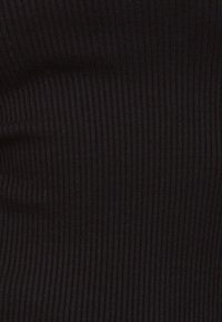 Tessuto nero a coste con una fine trama, caratterizzato da strisce verticali che creano profondità e un aspetto liscio. Nessun accento o pezzo hardware notevole.