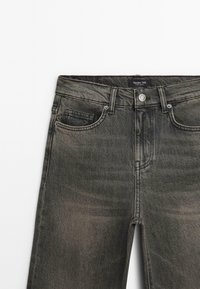 Dunkelgraue Denim-Jeans mit einem leicht verwaschenen Finish. Verfügt über fünf Taschen, einen Knopfverschluss und ein Etikett am Bund.