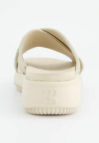 Beige open-back sandaal met cross-strap ontwerp, bovenkant van glad leer, textuur rubberen zool en gegraveerd logo op de hak.