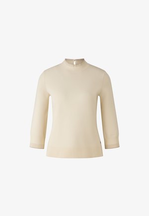 Sweter dzianinowy w kolorze kremowym z wysokim kołnierzem i krótkimi rękawami. Posiada prążkowany dół i mankiety oraz mały detal w postaci otworu na plecach.