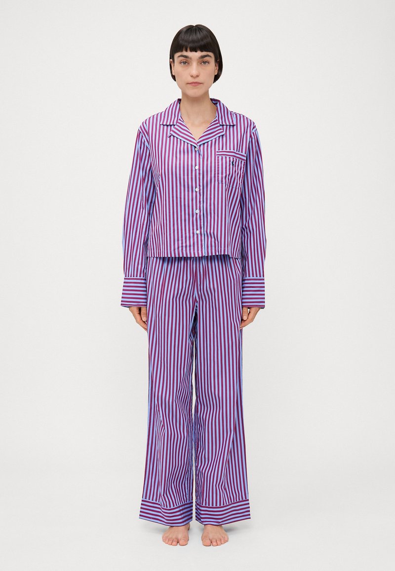 Pijama rayate mov și roz, cu un top butonat cu guler și un buzunar, împreună cu pantaloni largi asortați. Material neted și ușor.