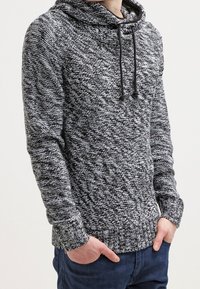 Strick-Hoodie in schwarz-weißem Melange-Muster, mit Kordelzug, gerippten Bündchen und Saum. Legere Passform mit strukturiertem Aussehen.