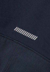 Námořnická tkanina s hladkým povrchem, která má uprostřed reflexní stříbrný vodorovný pruhovaný logo. Šité okraje zajišťují odolnost.