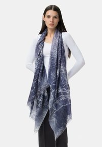 Sciarpa a motivi viola e blu con una consistenza morbida e trasparente, caratterizzata da bordi frangiati e elementi di design intricati in tutto.
