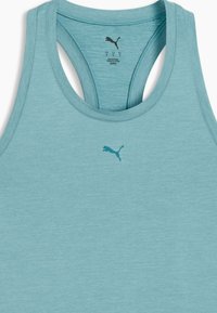 Ένα αθλητικό αμάνικο μπλουζάκι σε ανοιχτό τιρκουάζ χρώμα μ ε σχέδιο racerback και μικρό σκούρο λογότυπο τοποθετημένο κεντρικά στο στήθος. Μαλακό, υφασμάτινο με υφή.