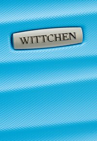 Bagages texturés bleus avec une plaque logo en argent WITTCHEN. La surface présente des motifs en relief et un design élégant et robuste.