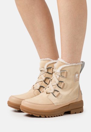 Μπεζ αδιάβροχες μπότες με σουέτ υλικό, σχέδιο με κορδόνια, γκρίζες λεπτομέρειες και πλούσια επένδυση. Διαθέτουν υφασμάτινη σόλα από καουτσούκ με προφίλ.