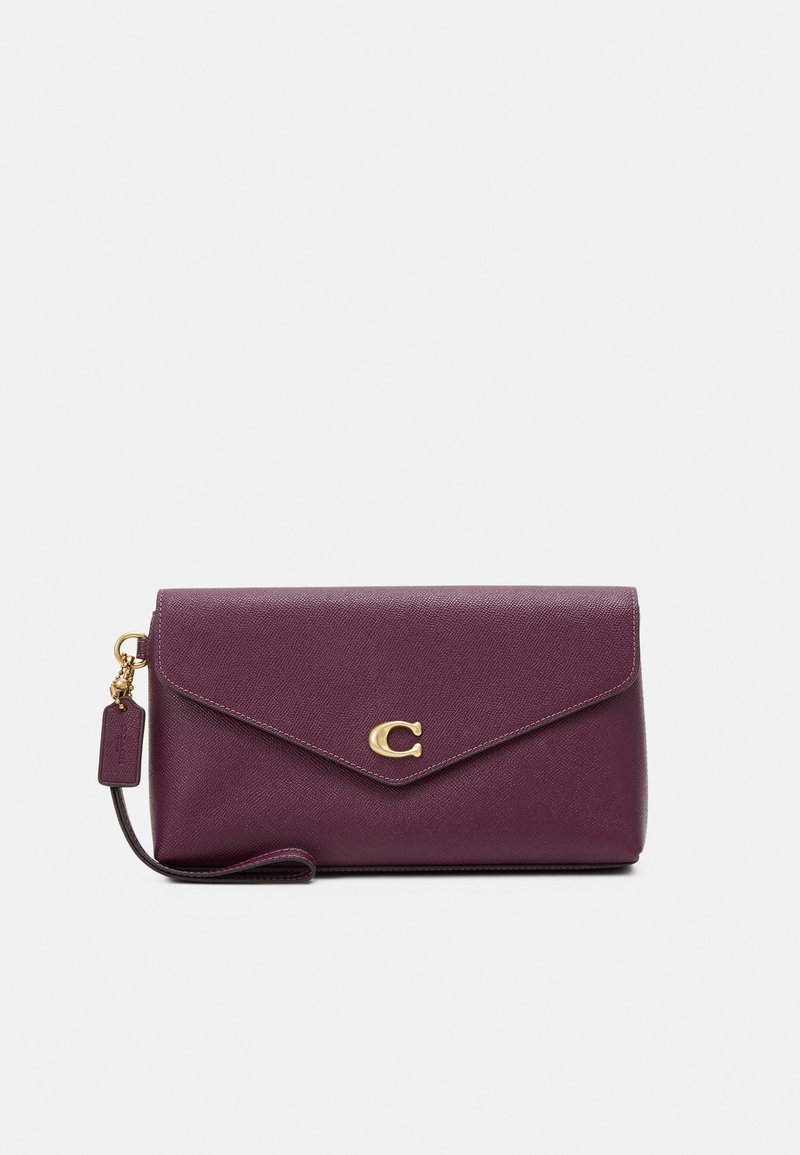 Pochette bracelet en cuir violet foncé avec une fermeture dorée en forme de lettre C et une étiquette en cuir assortie sur la sangle du poignet.