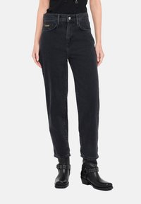 Jeans in denim nero con vita alta e design a gamba dritta. Presentano tasche frontali, chiusura con zip e un accento dorato del logo sulla cintura.