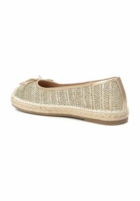 Bailarina de oro tejida con una superficie texturizada, abertura elástica y suela de yute trenzada. Presenta un pequeño lazo decorativo en la parte frontal.