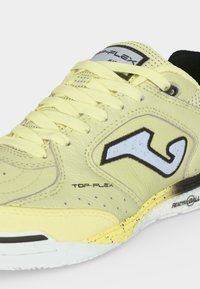 Κίτρινο αθλητικό παπούτσι με μαύρο και λευκό λογότυπο, κίτρινα κορδόνια και λευκή σόλα με το κείμενο "Reactive Ball" και σποραδικό μοτίβο στη μεσαία σόλα.