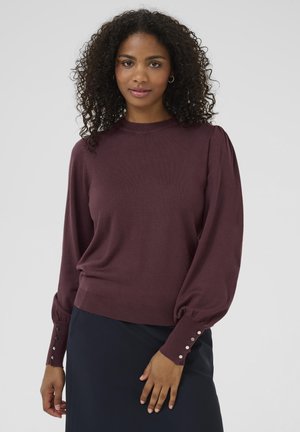 Pull en maille bordeaux avec des manches longues bouffantes et des accents de boutons aux poignets. Présente un col rond et une coupe décontractée.