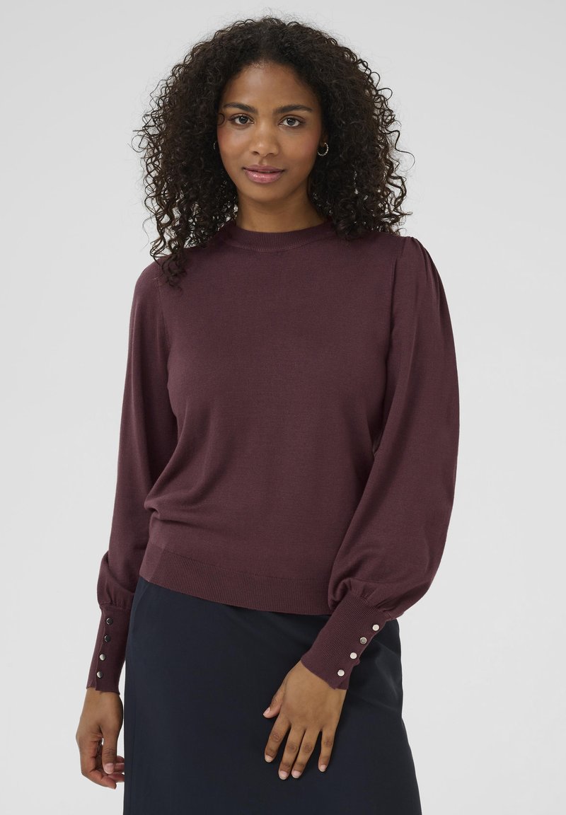 Burgundy knit sweater with puffed long sleeves and button accents at the cuffs. Features a round neckline and a relaxed fit.