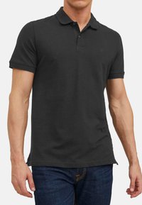 Sort polo shirt lavet af bomuld, med en veldefineret krave, to-knaps lukning og korte ærmer. Simpelt, ensfarvet design.