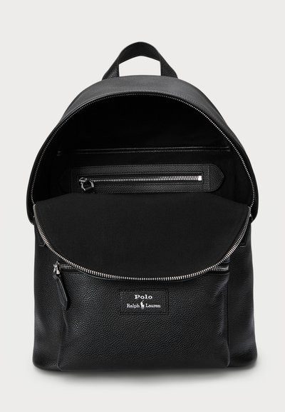 Black leather backpack with textured finish, rounded top, zippered closure, interior pockets, and logo on the front.